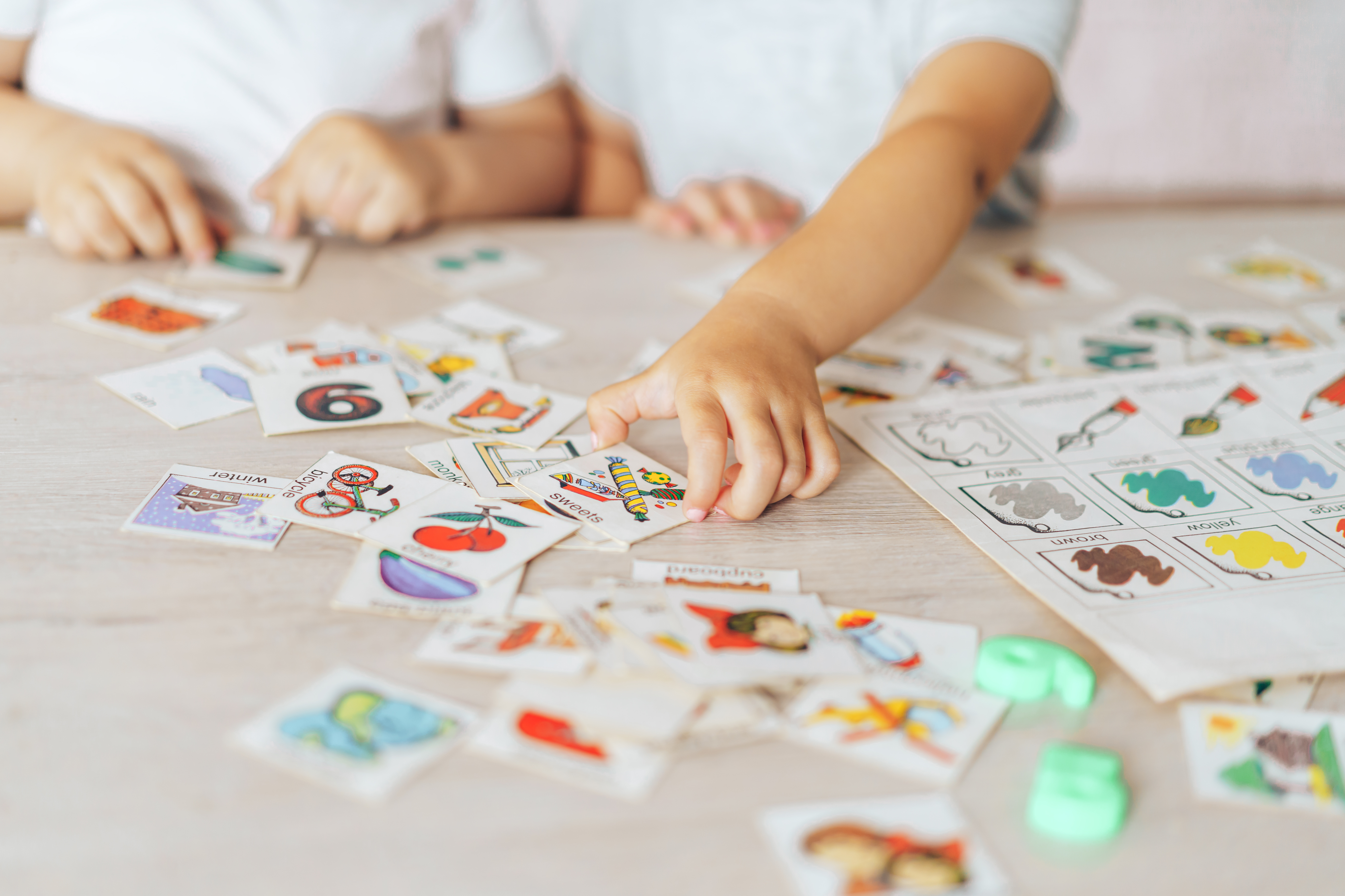 Kinder sortieren ausgeschnittene Kärtchen mit Symbolen